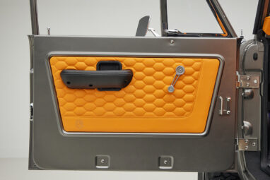 1972 classic ford bronco in matte silver with orange leather interior door panel