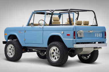 A 1976 Classic Ford Bronco is Frozen Blue over White Rock leather driver rear 3/4
