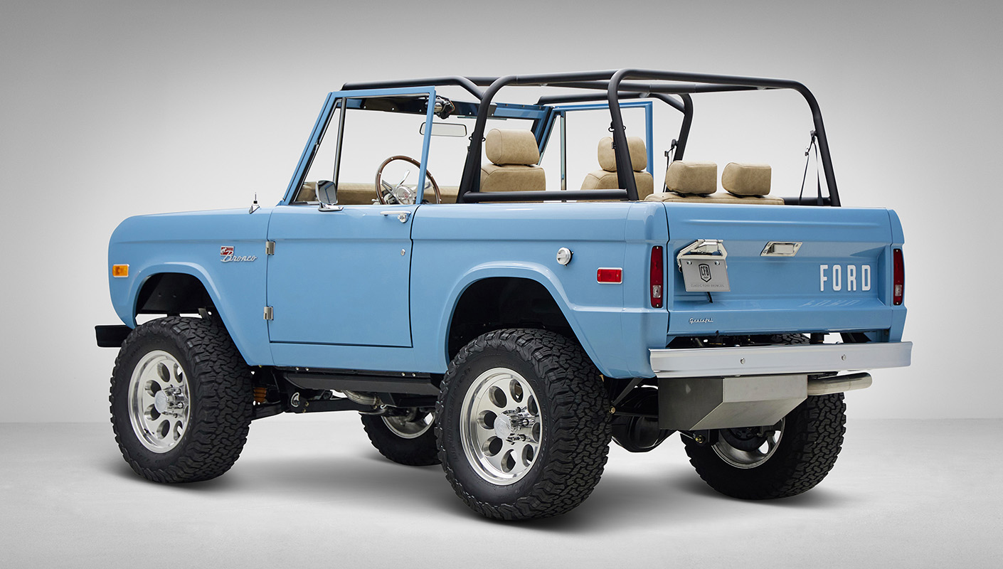 A 1976 Classic Ford Bronco is Frozen Blue over White Rock leather driver rear 3/4