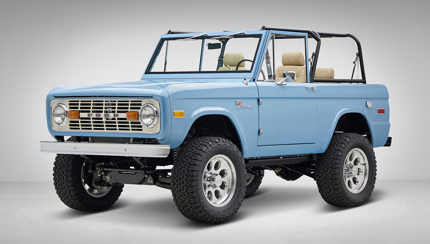 A 1976 Classic Ford Bronco is Frozen Blue over White Rock leather driver front 3/4