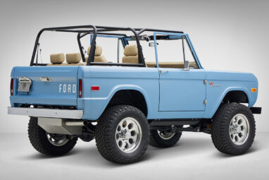 A 1976 Classic Ford Bronco is Frozen Blue over White Rock leather passenger rear 3/4