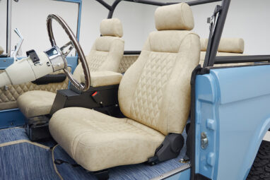 A 1976 Classic Ford Bronco is Frozen Blue over White Rock leather driver interior