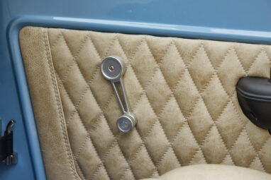 A 1976 Classic Ford Bronco is Frozen Blue over White Rock leather custom door inserts