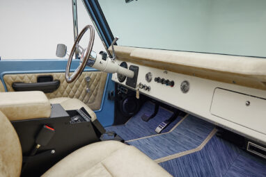 A 1976 Classic Ford Bronco is Frozen Blue over White Rock leather custom dash