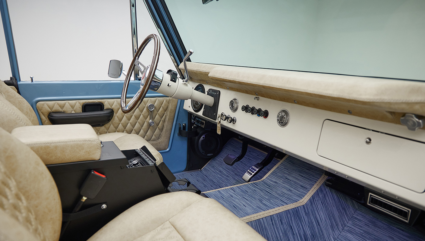 A 1976 Classic Ford Bronco is Frozen Blue over White Rock leather custom dash