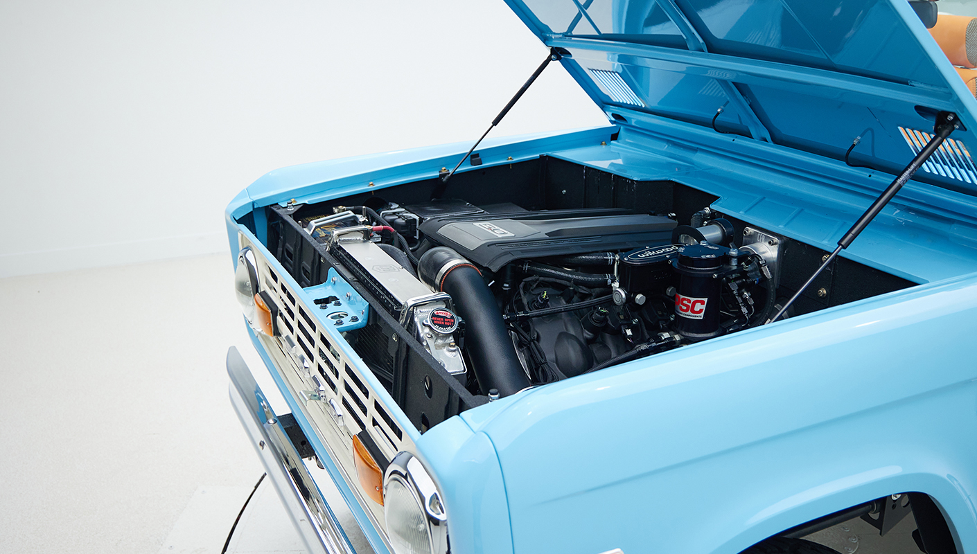 1973 Classic Ford Bronco in frozen blue with rolls royce orange leather and alpaca interior motor angle